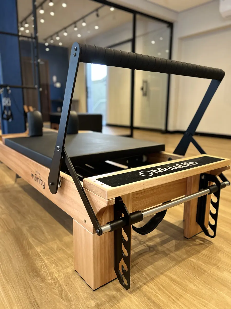 Reformer de madeira com barra de pés, no salão do studio